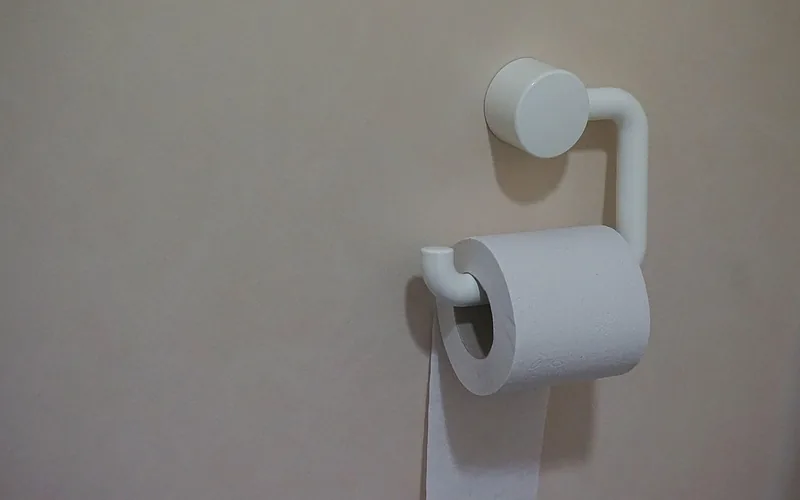 toilet paper roll hanging in the over orientation on a wall holder