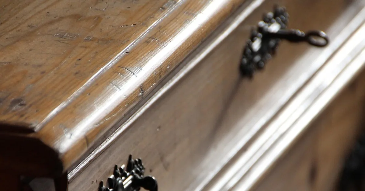 Close-up of wood furniture surface with visible water marks and stains
