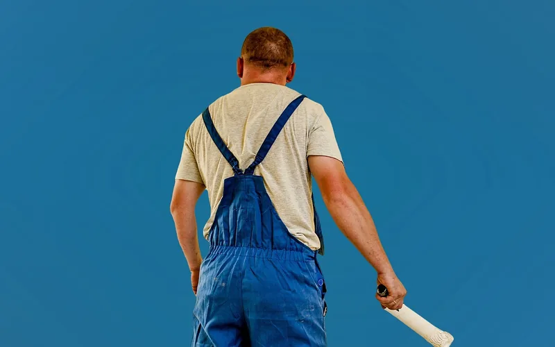 Person holding a paint roller, ready to prime and paint a ceiling after popcorn texture removal