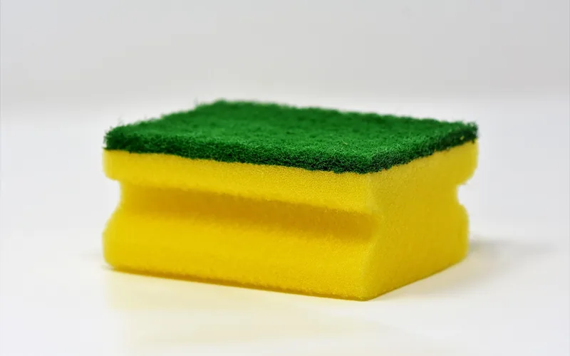 two-sided cleaning sponge with a soft yellow side and an abrasive green scrub side