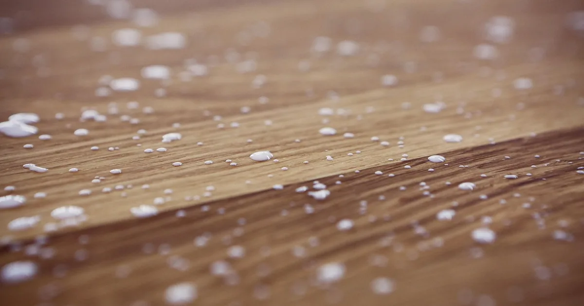 dried white wood glue drips scattered across a wood plank surface