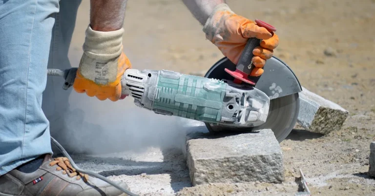Angle grinder fitted with a cutting blade slicing stone