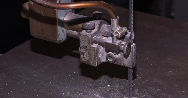 Close-up of a band saw blade cutting through a wooden workbench
