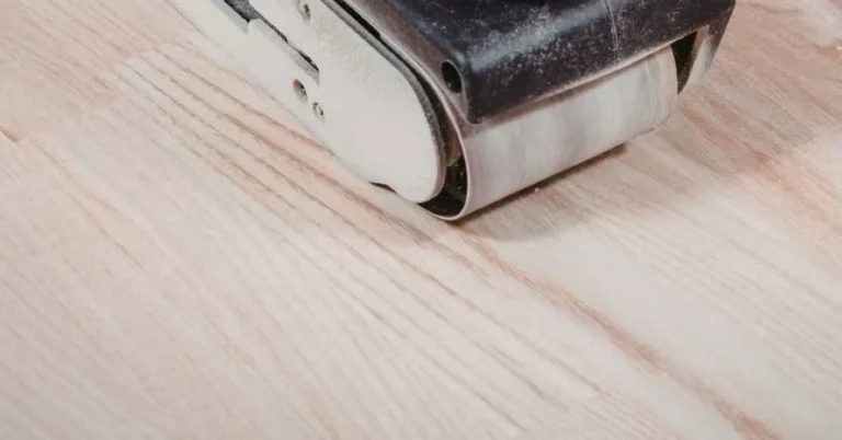 Belt sander sanding a hardwood floor closeup