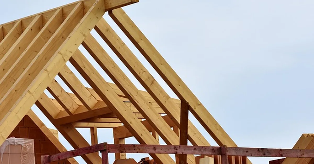 Freshly built wood roof rafters and trusses at a house construction site