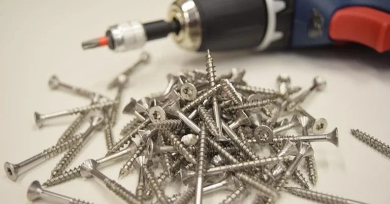 Cordless drill and pile of screws for a screw removal project