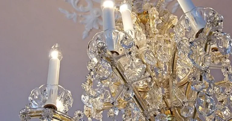 Crystal chandelier mounted on a decorative ceiling medallion before removal