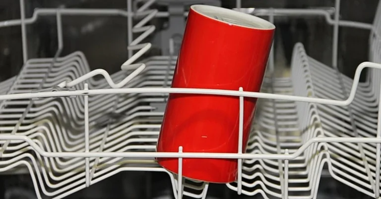 Open dishwasher interior with rack loaded for washing