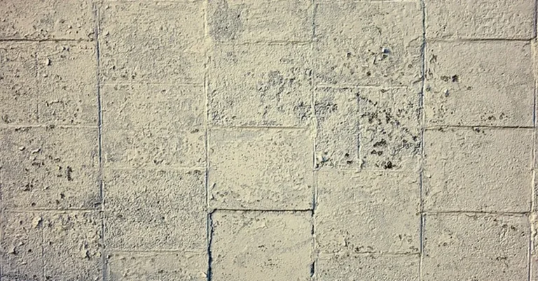 Flaking paint on a concrete block wall before non-chemical paint removal