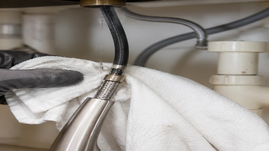 Pull-out kitchen faucet hose and spray head inspected for a leak