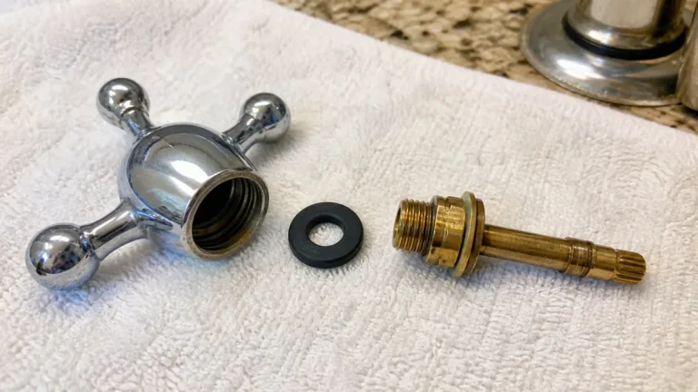 Compression faucet stem with rubber washer and retaining screw removed for a leak repair
