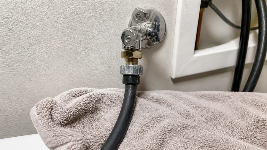 Laundry sink faucet and washer supply connections checked for leaks with a dry cloth