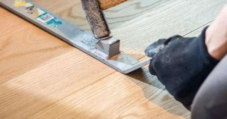 Tapping a threshold transition strip flush with a mallet