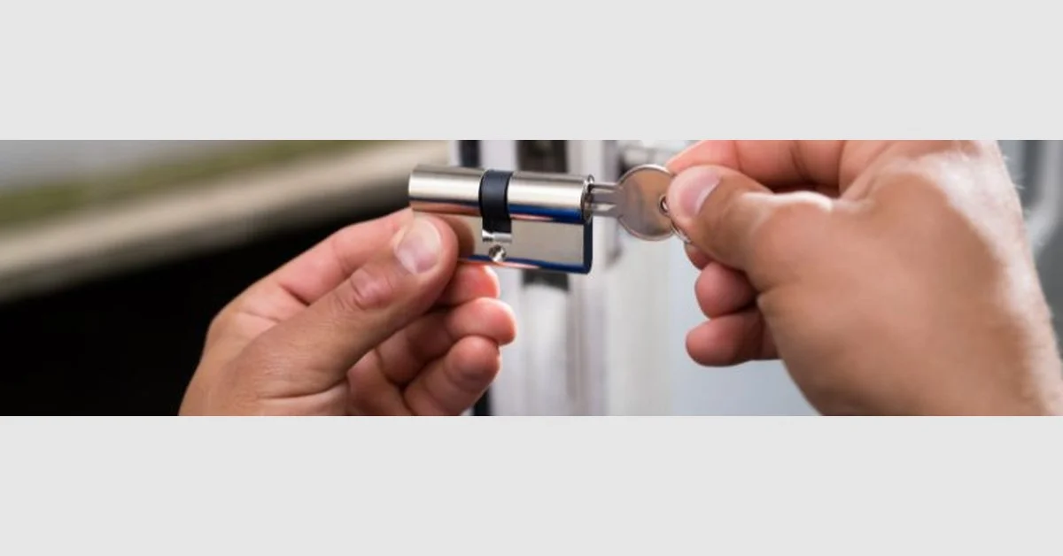 Hands installing a new lock cylinder into a patio door with key