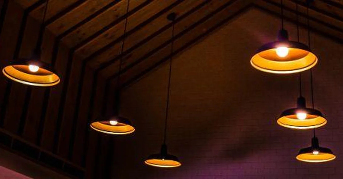 Multiple pendant lights hung at varied lengths from a vaulted wood beam ceiling