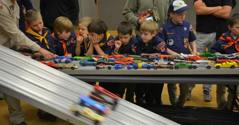 Cub Scouts watching pinewood derby cars race down the track