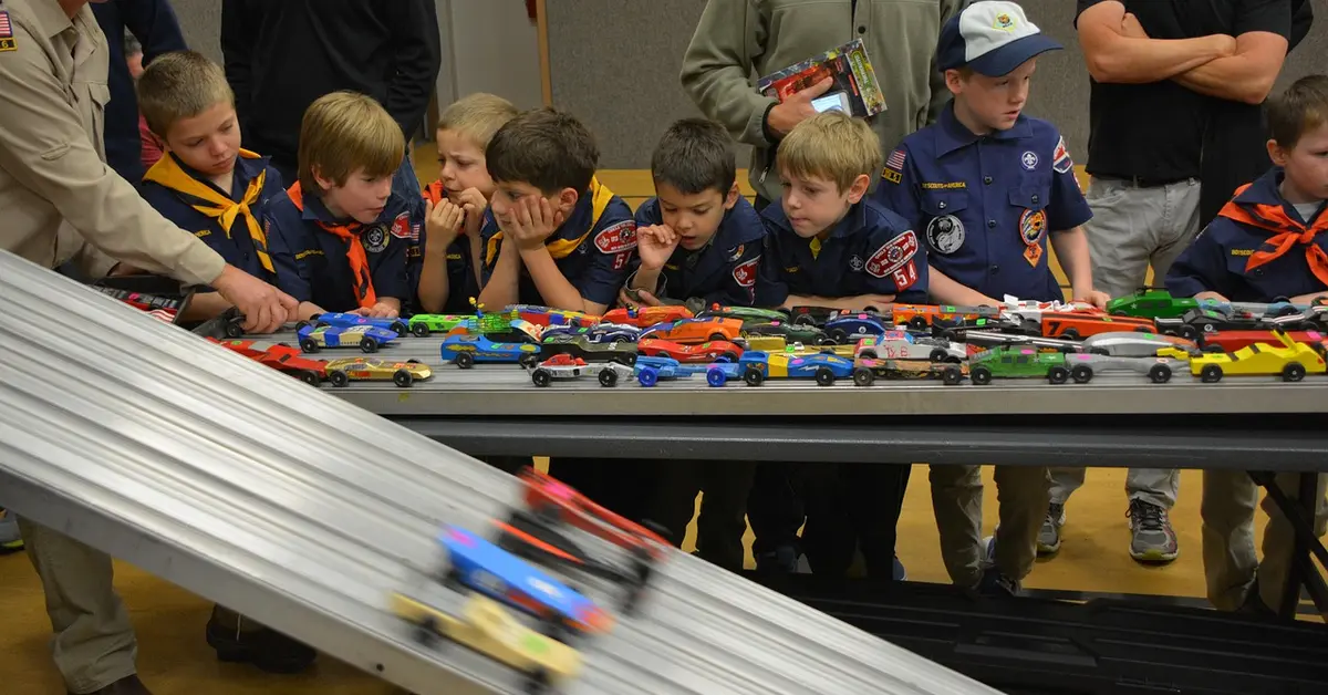 Cub Scouts watching pinewood derby cars race down the track