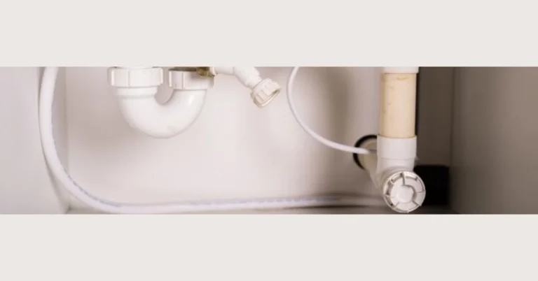 P-trap and PVC pipes under a bathroom sink closeup