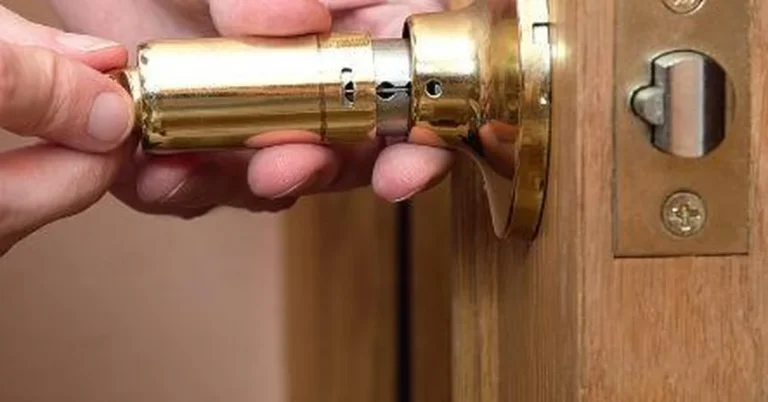 Hands removing a deadbolt lock cylinder from a door