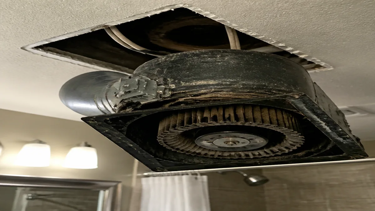 Old bathroom fan housing and replacement motor compared during a noise repair