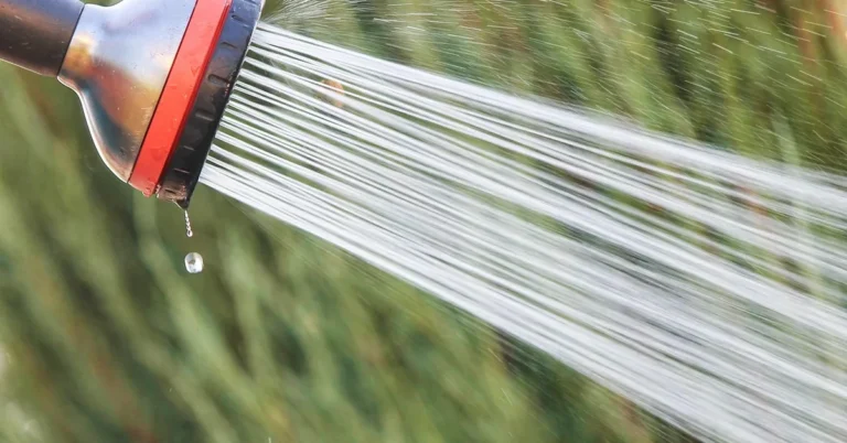 Shower head spraying water used to illustrate low water pressure issues