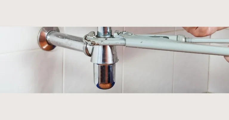 Sink P-trap and drain plumbing closeup under a bathroom sink