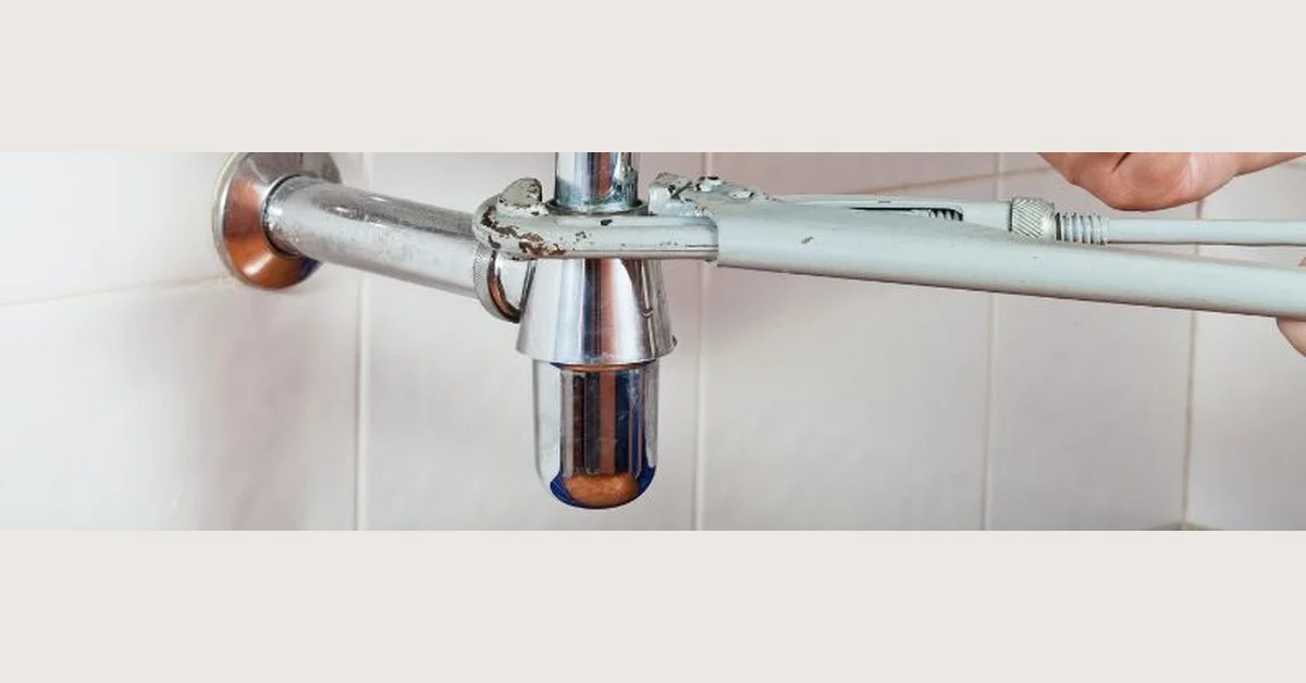 Sink P-trap and drain plumbing closeup under a bathroom sink