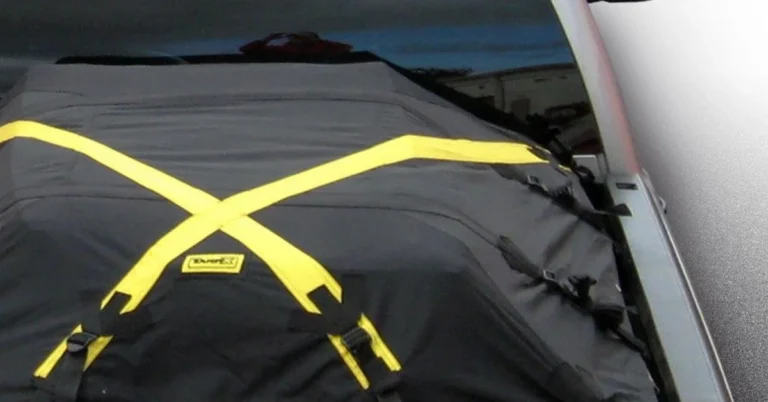 Truck bed tarp secured with crossing straps over cargo