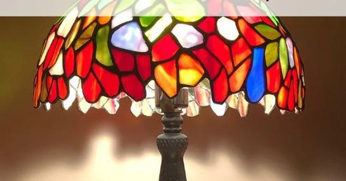 Finished Tiffany-style stained glass lamp shade glowing on a lamp base