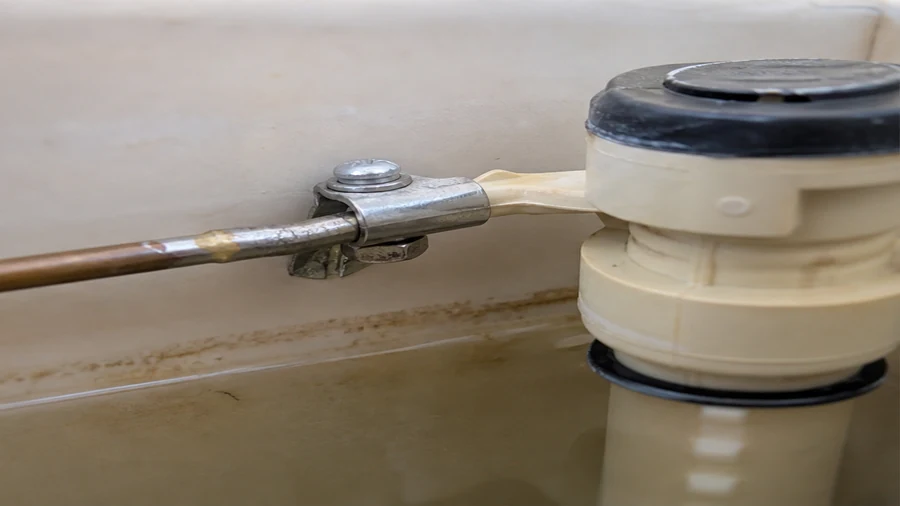 Ball-float toilet fill valve checked inside a running toilet tank