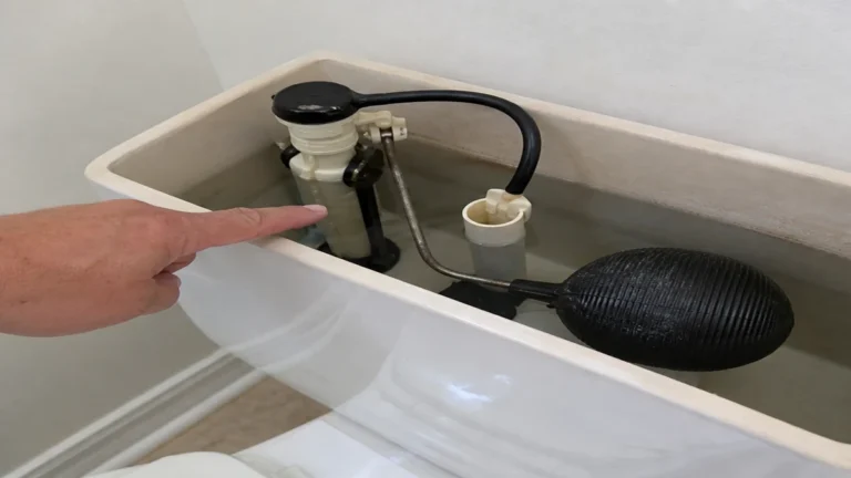 Ball-float toilet fill valve checked inside a running toilet tank
