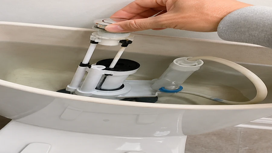Push-button toilet flush mechanism inspected inside an open cistern