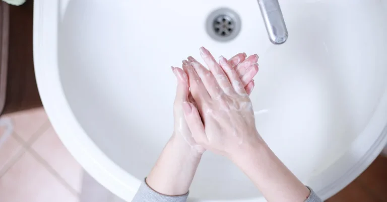 Washing hands with soap and cold water at a sink
