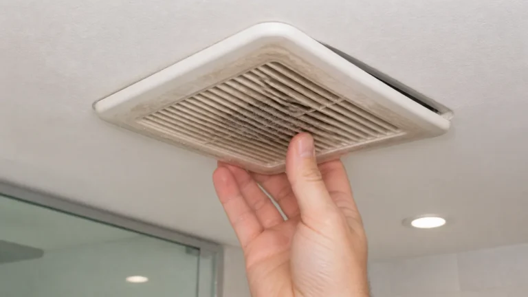 Dusty bathroom exhaust fan grille and blower wheel inspected for rattling and loud operation