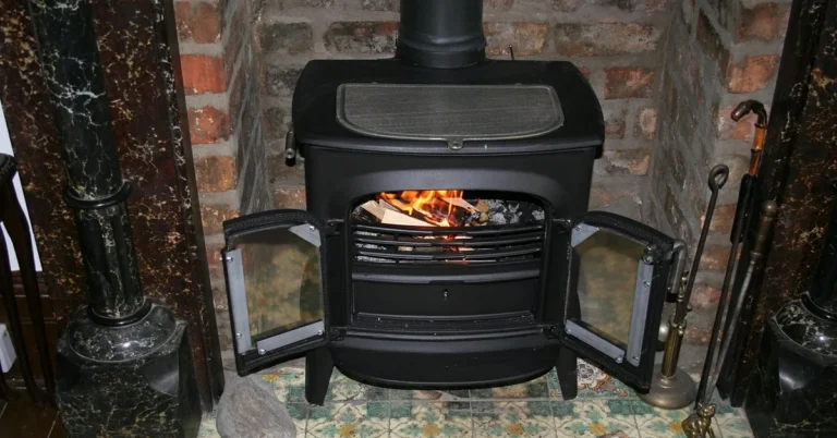 Wood burning stove with visible flame and chimney flue pipe