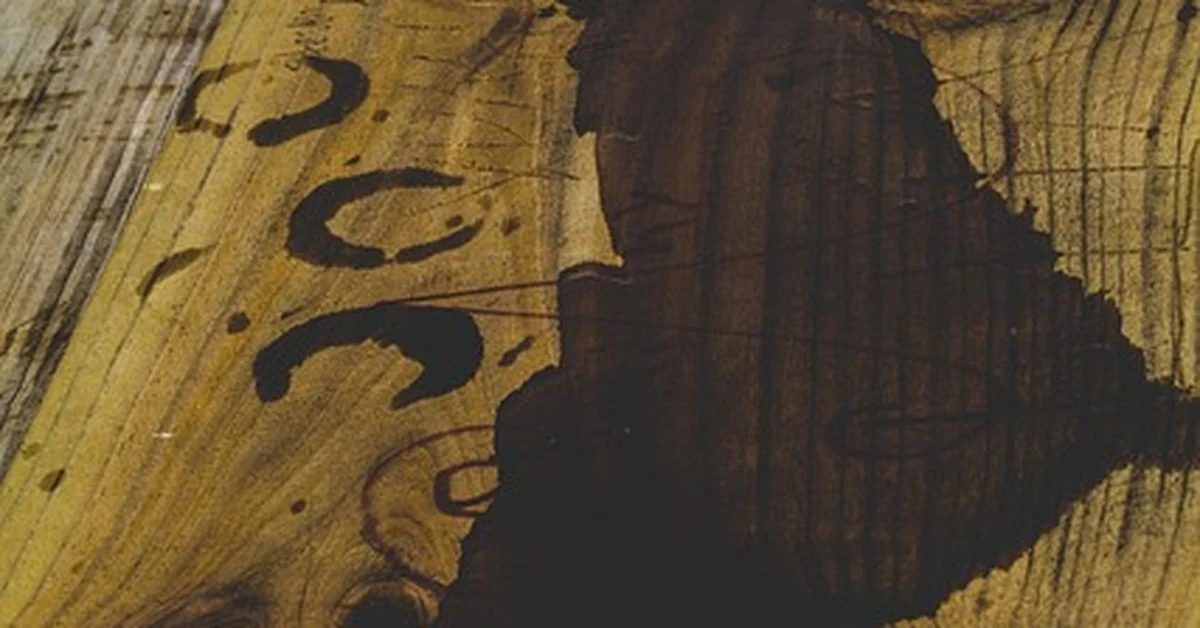 Dark water stain soaked into wood coffee table grain before repair