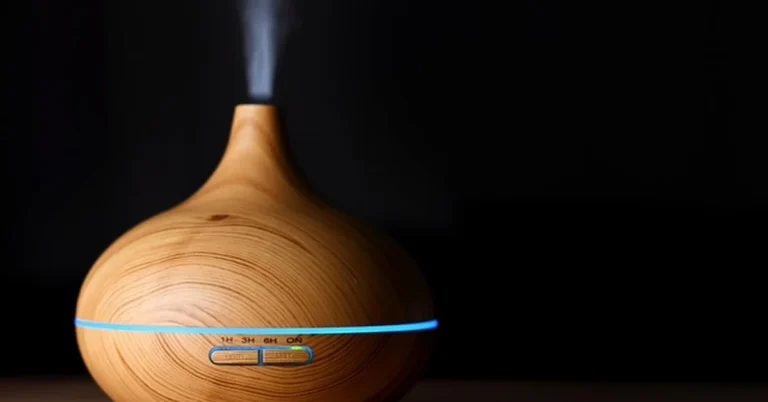 Wood-grain essential oil diffuser releasing mist on a wooden table