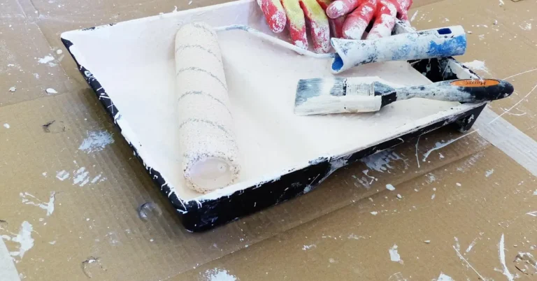 Paint roller loaded with paint being used on a wall