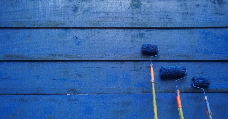 A paint roller applying white paint to a wall.