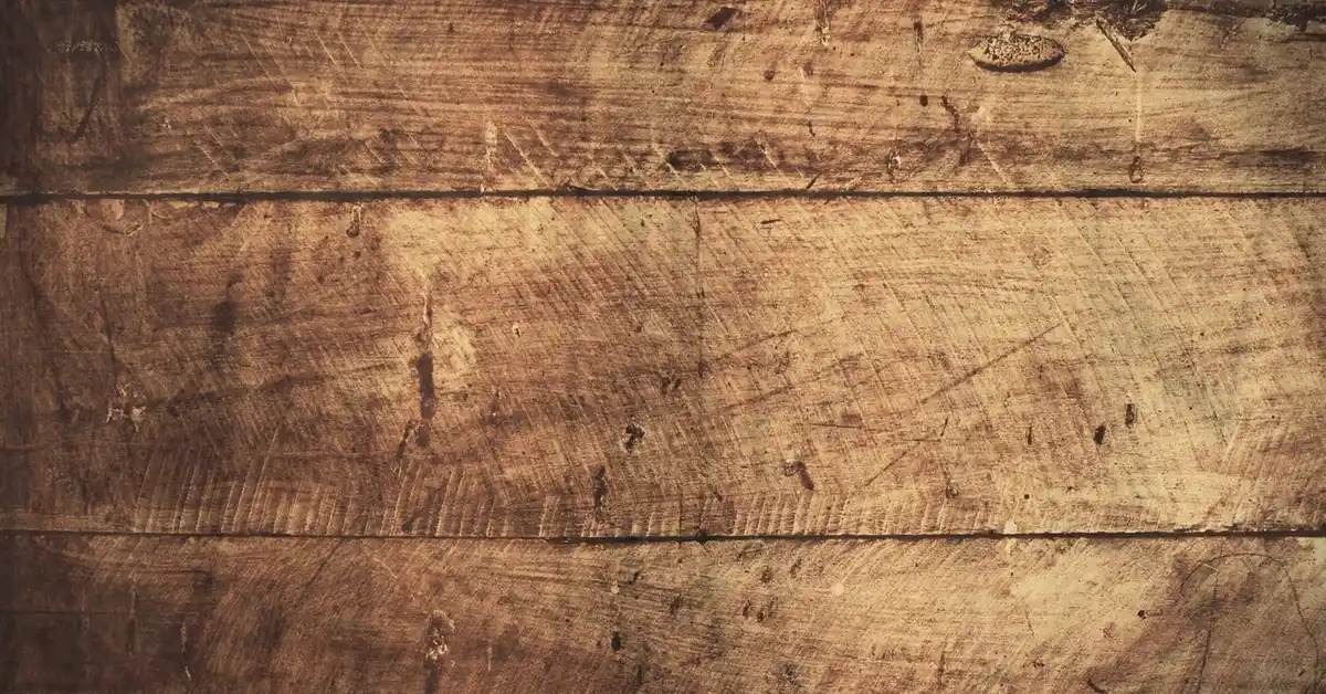 A close-up of scratched wood flooring.