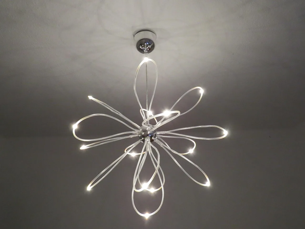How low should a ceiling fixture hang in a room with limited headroom?