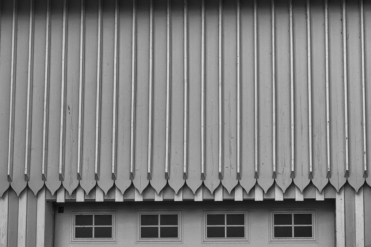 Homeowner lubricating garage door rollers, hinges, and spring in a garage
