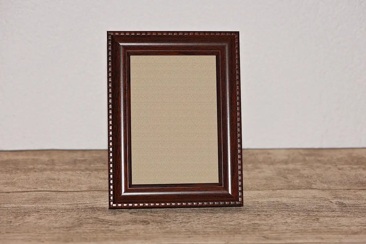 Picture frame wood samples on a workbench with a hand checking grain and flatness