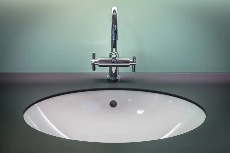 Modern bathroom vanity with brushed nickel faucet, chrome towel bar, and stainless steel accents