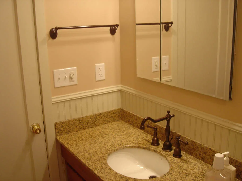 Close-up of brushed nickel and chrome faucet finishes showing water spotting on chrome