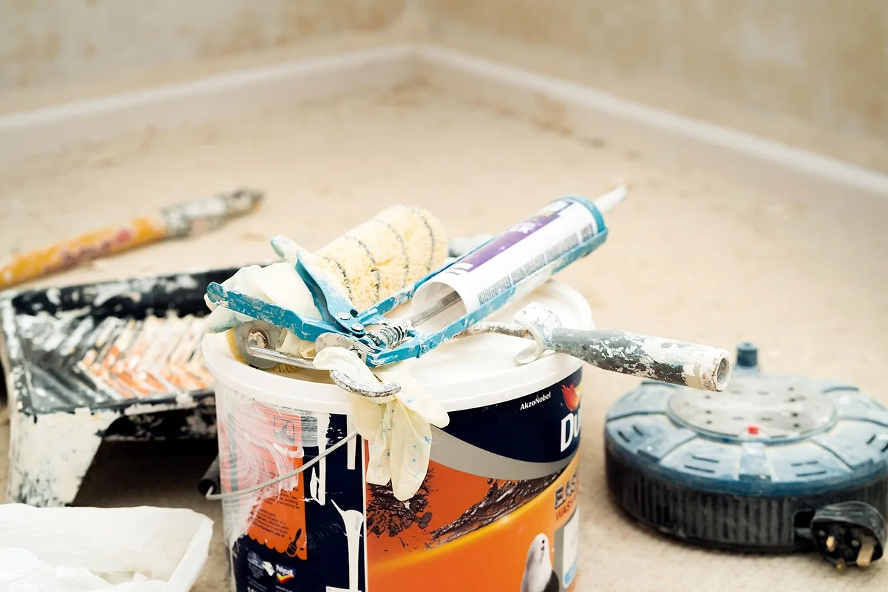 Homeowner and contractor compare three tubes beside a bathroom sink and painted trim