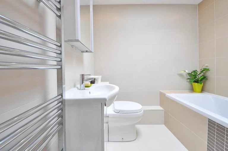 Modern bathroom with sink, toilet, bathtub, towel rack, and potted plant