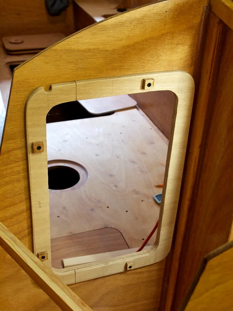 Hand measuring drywall thickness beside a wood stud and drywall screw