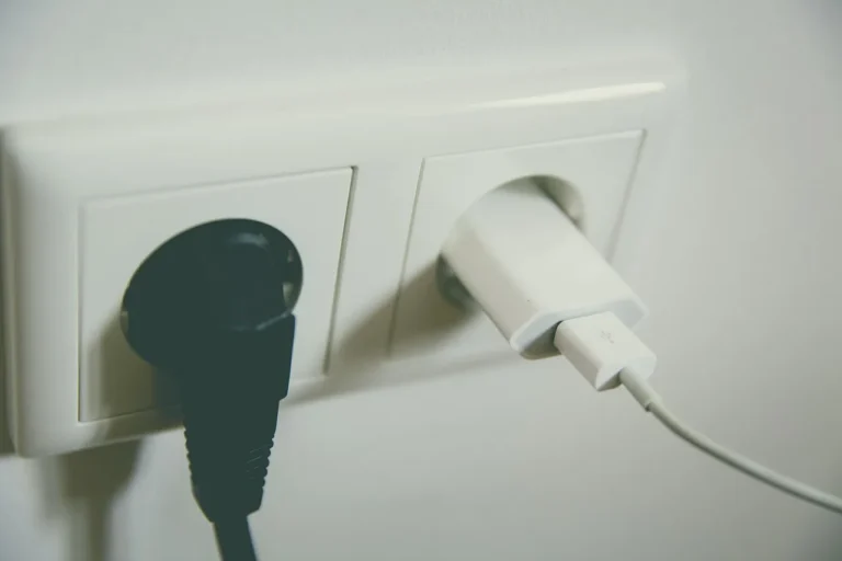 Homeowner and electrician comparing electrical outlets and receptacles on a kitchen counter