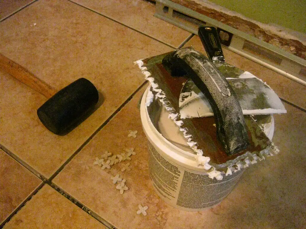 Clamped wooden chair joint with fresh glue bead being wiped clean